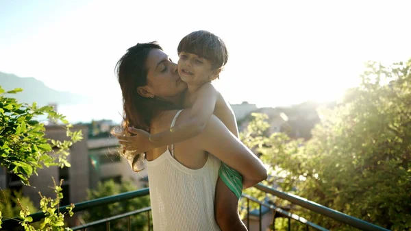 日落时 慈祥的母亲抱着孩子站在室外的风景中 有爱心的父母拥抱小男孩 — 图库照片