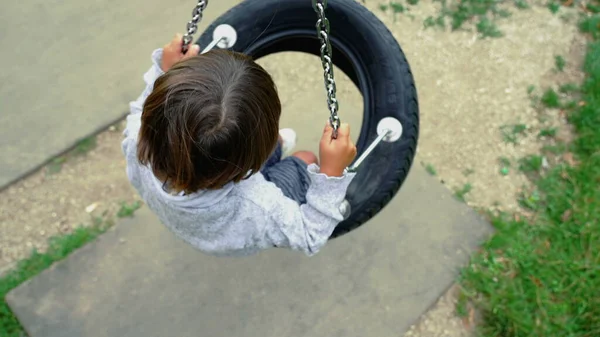 Child Seated Tire Swing Spinning Playground Park Daydreaming Top View — Stok fotoğraf