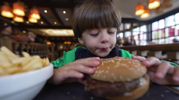 Gyerek Hamburgert Vesz Eszik Egy Kisfiú Nagy Hamburgerrel Kezében Kaukázusi — Stock videók