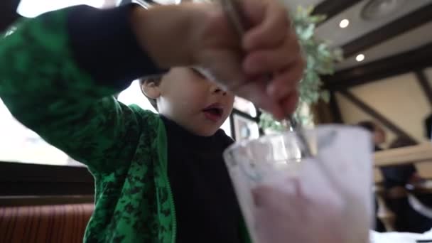 Голодный Ребенок Ест Десерт Мороженым Ресторане После Еды — стоковое видео