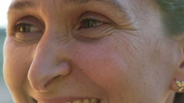 One joyful woman macro eyes close up smiling. Portrait eye female person in 40s looks at camera. Happiness concept