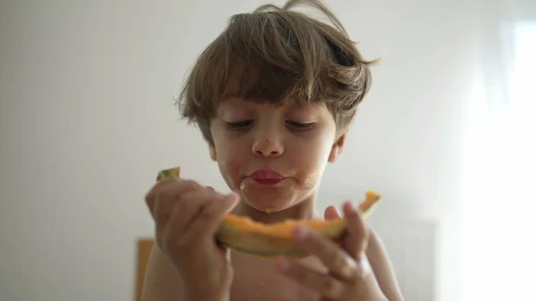 One Small Boy Devouring Yellow Melon Fruit Indoors Portrait Face — Stok fotoğraf