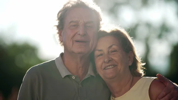 Happy Senior Couple Posing Camera Standing Nature Older Husband Embracing — Fotografia de Stock