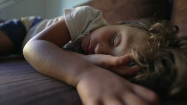 Uyuyan çocuk kanepede uyuyor. Çocuk öğle uykusunda derin uykuda. Tatlı yorgun çocuk dinleniyor.