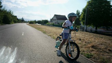 Aktif çocuk bisiklet sürmeyi öğreniyor. Çocuk bisiklet sürerken dengesini kaybediyor.