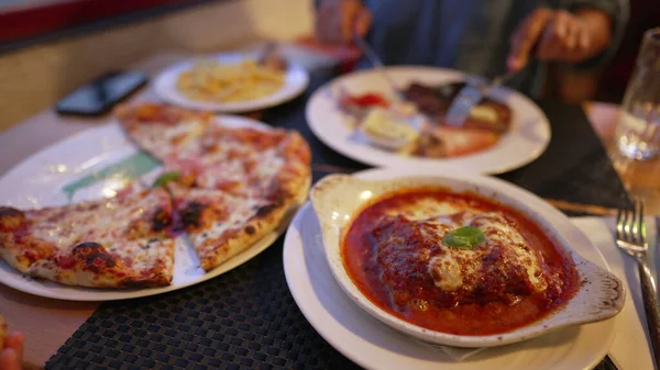 Πιάτα Φαγητού Στο Εστιατόριο Άνθρωπος Κόβει Μπριζόλες Πίτσα Και Λαζάνια — Φωτογραφία Αρχείου