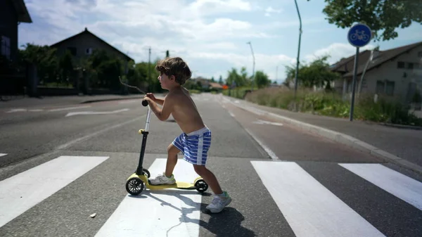 Kind Überquert Bei Sonnigem Wetter Mit Dreirädrigem Roller Die Straße — Stockfoto