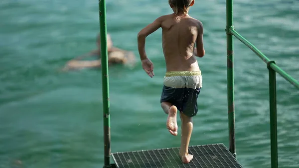 Dzieciak Zanurzający Się Wodzie Dziecko Bawiące Się Biegając Dokach Skacząc — Zdjęcie stockowe