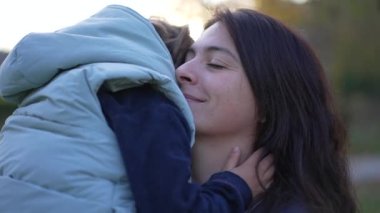 Anne ve çocuk parkta kucaklaşırlar. Küçük çocukla ebeveyn ilişkisi. Annelik sevgisi ve bakım yaşam tarzı