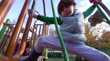 Küçük çocuk dışarıda antrenman yapıyor. Oyun alanındaki metal barda. Aktif Çocuk açık havada aktif. Çocukluk yaşam tarzı