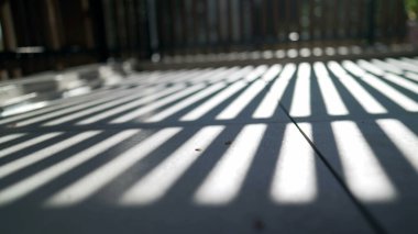 Balkon terasında yerde güneş ışığı desenleri var. Güzel gün ışığı.