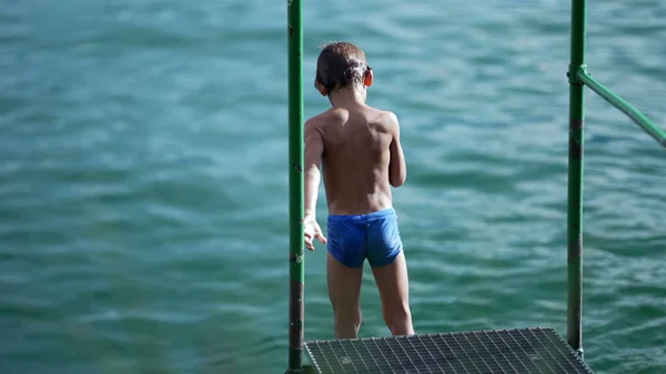 Ένα Μικρό Αγόρι Στέκεται Στο Κατάστρωμα Της Λίμνης Φορώντας Μαγιό — Φωτογραφία Αρχείου