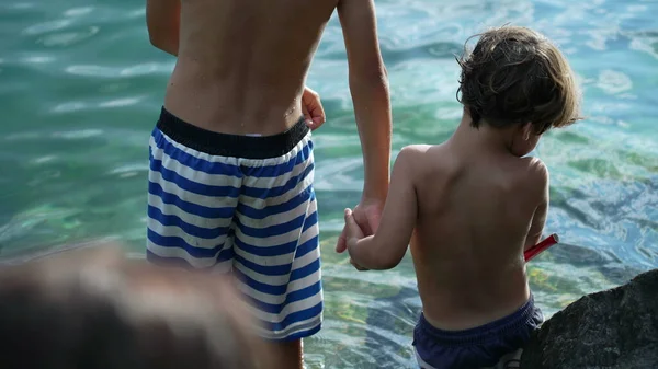Dwóch Braci Trzymających Się Ręce Nad Jeziorem Kostiumach Kąpielowych Rodzina — Zdjęcie stockowe