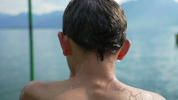 后面湿淋淋的小男孩站在湖边 少年望着江山 — 图库照片