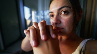 Contemplative woman thinking deeply at apartment balcony. Pensive female person in her 30s with thoughtful emotion. closeup face serious expression