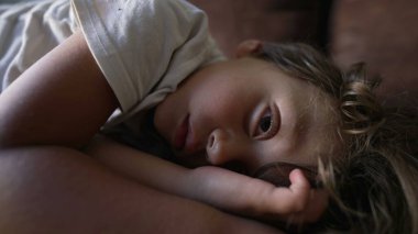 Küçük çocuk uykusundan uyanıyor. Çocuk kanepede şekerleme yaparken uyanıyor.