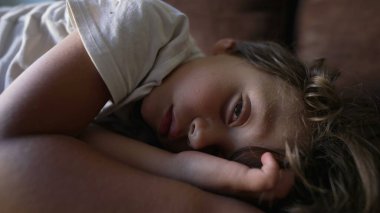 Küçük çocuk uykusundan uyanıyor. Çocuk kanepede şekerleme yaparken uyanıyor.