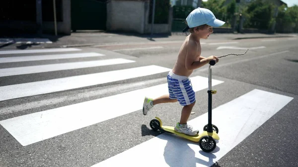 Kind Überquert Bei Sonnigem Wetter Mit Dreirädrigem Roller Die Straße — Stockfoto