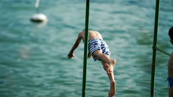 소년은 여름휴가를 즐기기 속으로 뛰어들었다 아이들 갑판을 뛰어들다 — 스톡 사진