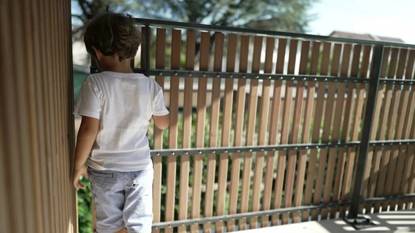 One Happy Small Boy Holding Balcony Wooden Bars Looking Out — Stock Photo, Image