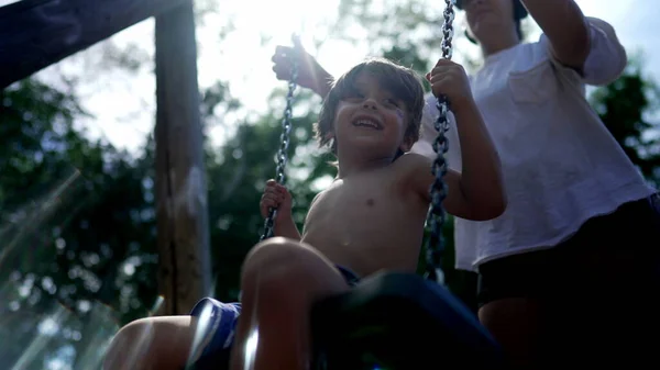 Glückliches Kind Sitzt Draußen Auf Spielwippe Und Hat Spaß Ohne — Stockfoto