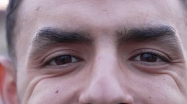 Orta Doğulu mutlu bir adam kameraya gülümseyen gözlerini kapatır. Makro, kırışıklıkları olan 20 'li yaşlarda bir Arap erkek.