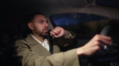 Geceleri direksiyon tutan endişeli bir adam. Orta Doğulu bir erkeğin sinirli ifadesi.
