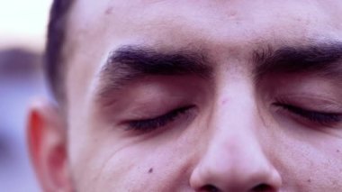 Düşünceli genç bir adam makro gözleri yakın çekim. Erkek Arap meditasyonda gözlerini kapatıp açıyor. Mutlu mutlu bir ifade