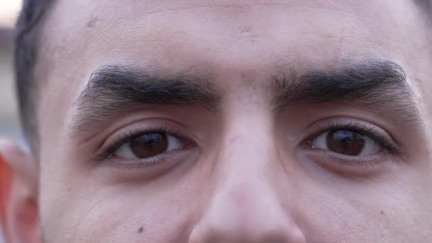 1人の若い中東アラブ人の男性がマクロな表現でカメラを見て目を閉じています 二十代男性近視 — ストック動画