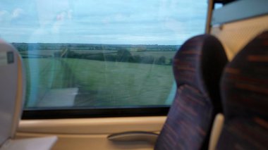 Manzara hareketli tren penceresinden görülüyor. Hareketli yüksek hızlı ulaşım. Boş koltuklar