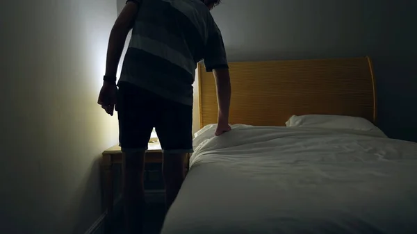 Man Prepares Bed Sleep Person Lays Bed Turns Night Stand — Zdjęcie stockowe