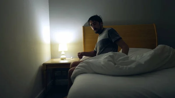 Man Prepares Bed Sleep Person Lays Bed Turns Night Stand — Zdjęcie stockowe