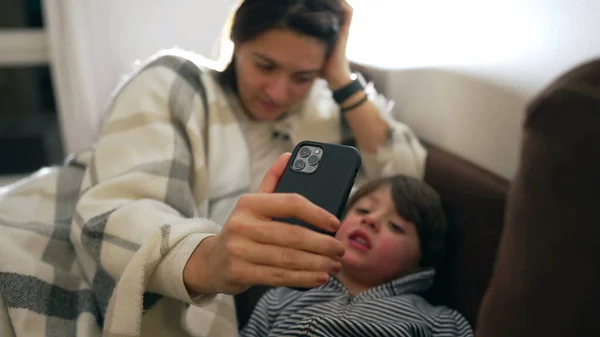 어머니는 아이가 동영상 통화를 수있도록 핸드폰을 있습니다 스마트폰을 사용하여 대화를 — 스톡 사진