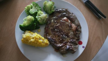 Sebze tabağında BeeF 'e SALT koymak. Brokoli ve mısırlı biftek.