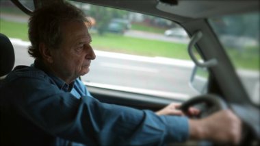 Senior driving inside moving vehicle. Older person holding car steering wheel driving on road. Person traveling