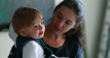 Casual mother and baby together at home. Mom and one year old toddler relationship