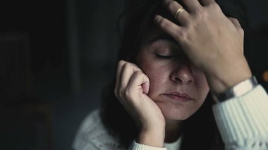 One thoughtful woman adjusting hair at home with pensive expression