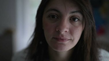 Woman changing emotion pressing lips becoming serious. Portrait face closeup of a female person in 30s change expression. Real authentic people looking at camera interior