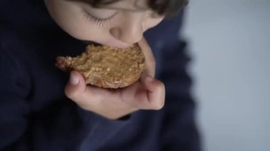 Fıstık ezmeli çocuk molası. Sabah kahvaltısında tost yiyen küçük bir çocuğun portresi.