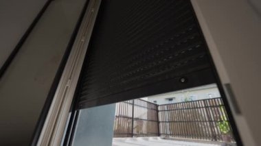 Elektrik panjurlarını kapatıyorum. Düşük açılı akıllı motorlu pencere aşağı iniyor. Modern Otomasyon