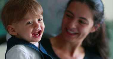 Cute baby real life smile and laugh, Portrait of one year old toddler boy smiling, happy mother and infant together