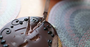 Cutting birthday cake slice, close-up of knife slicing chocolate cake