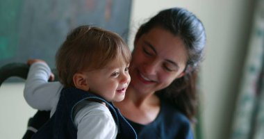 Mother and baby loving relationship. Casual mom real life smiling and laughing