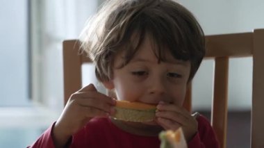 Karpuz meyvesi yiyen genç bir çocuk. Yakışıklı bir çocuğun portresi sabah kahvaltısında sağlıklı yiyecekler yiyor.