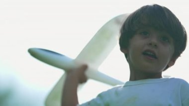 Genç çocuk parkta oyuncak fırlatıyor. Çocuk dışarıda köpük uçak planörüyle oynuyor. Uçuş Konseptini Al