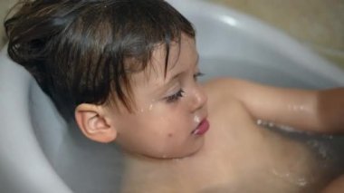 Küvetin içindeki küçük çocuk. Bebek banyoda banyo yapıyor. Vücut temizliği rutinini yıkıyor.