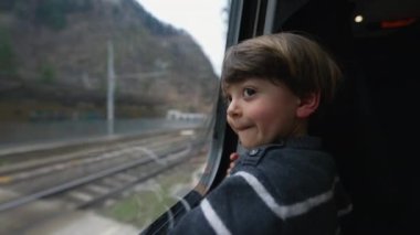 Yolcu çocuk tren penceresinden yansıyor. Buradan geçen manzaraya bakan küçük bir çocuk. Düşünceli çocuk.