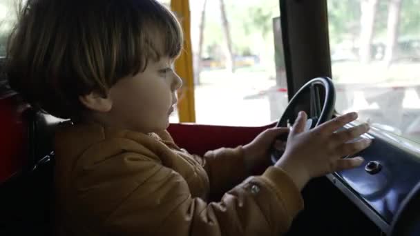 Один Радостный Ребенок Играет Рулем Внутри Карусели Автомобиля Парке Развлечений — стоковое видео