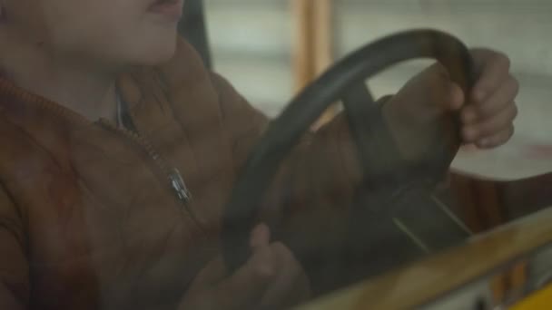 Criança Segurando Volante Parque Diversões Carro Carrossel Reflexão Luz Vidro — Vídeo de Stock