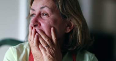 Stressed out older woman in 60s covering face with hands. Anxious worried senior woman feeling anxiety